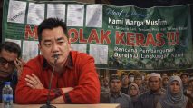 Ilustrasi Anggota DPRD Kota Jambi dari Fraksi PDI Perjuangan, Hendra Bongsu dan spanduk penolakan gereja. [TanyaFakta.co/Ados]